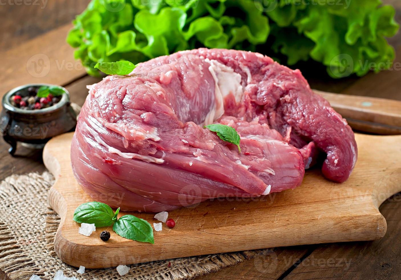 Piece of raw pork tenderloin on a wooden background photo