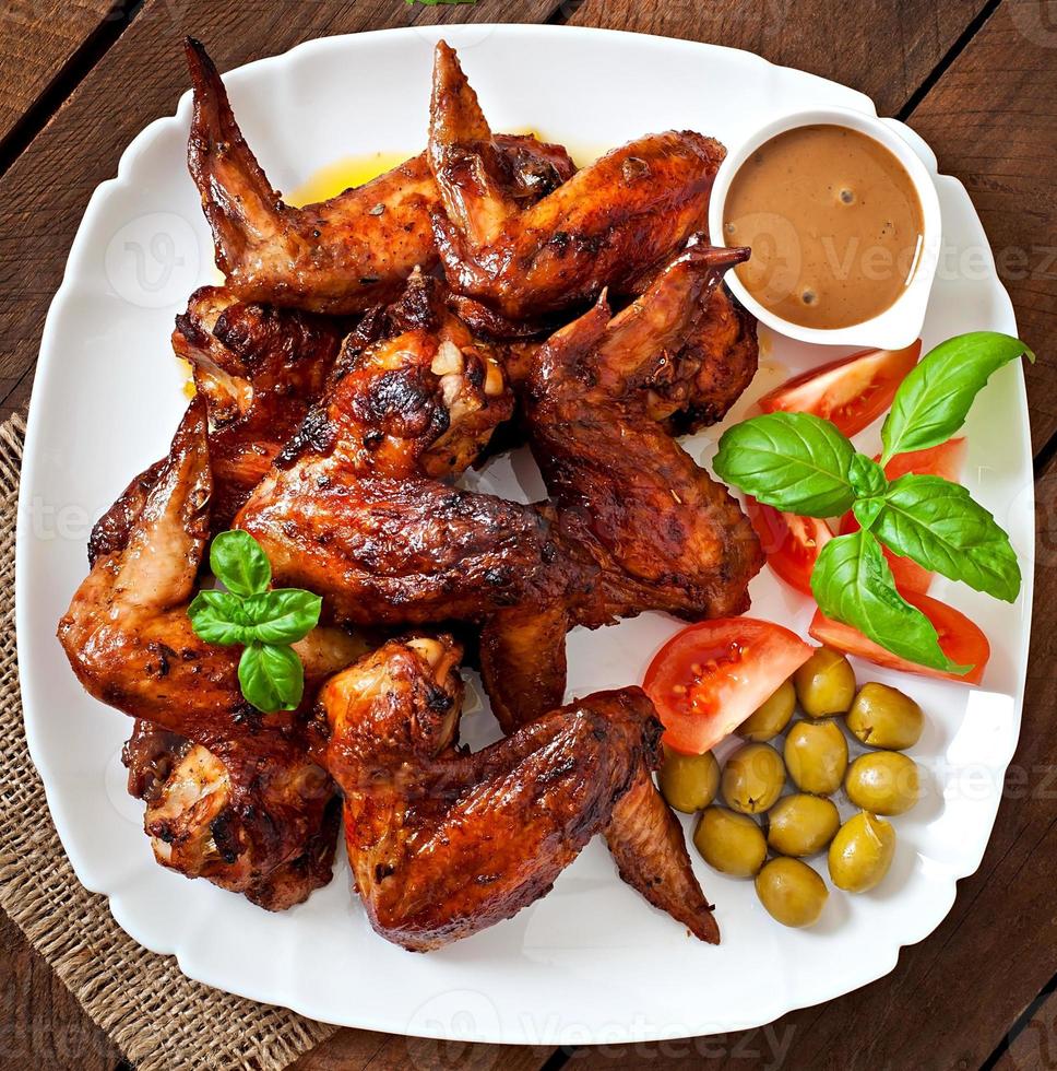 Plate of chicken wings on wooden background photo