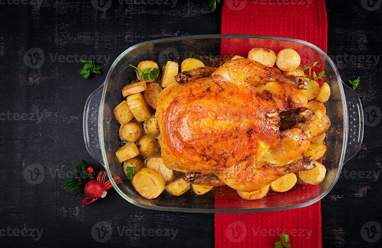 Baked turkey or chicken. The Christmas table is served with a turkey, decorated with bright tinsel. Fried chicken, table. Christmas dinner.  Top view, above photo