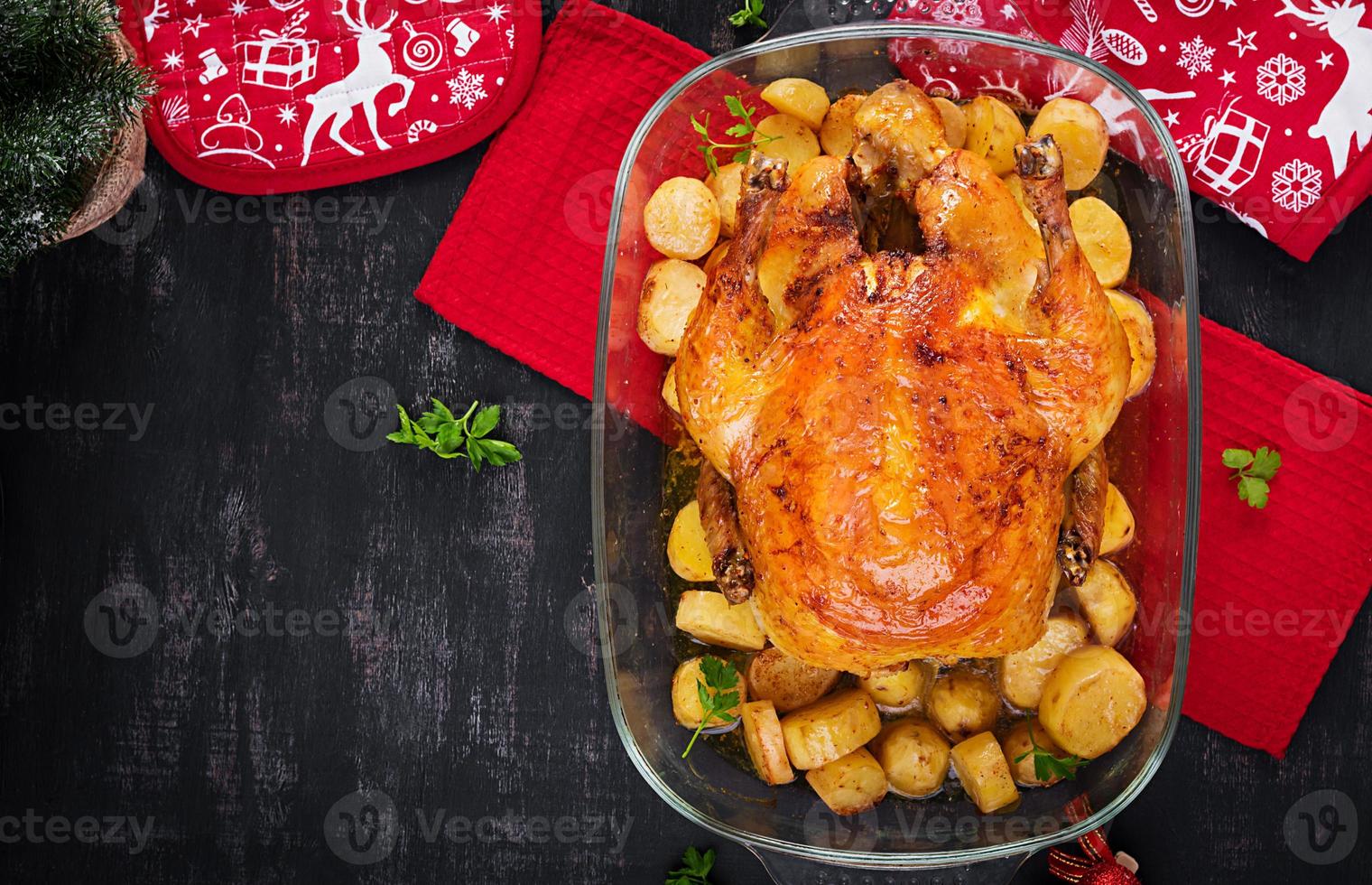 Baked turkey or chicken. The Christmas table is served with a turkey, decorated with bright tinsel. Fried chicken, table. Christmas dinner.  Top view, above photo