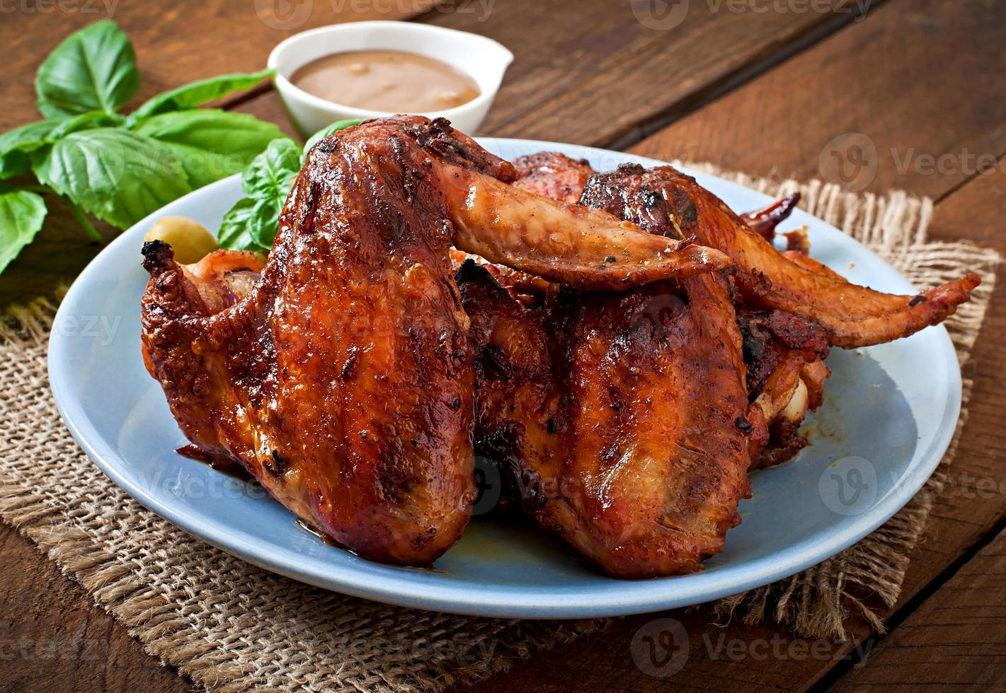 Plate of chicken wings on wooden background photo