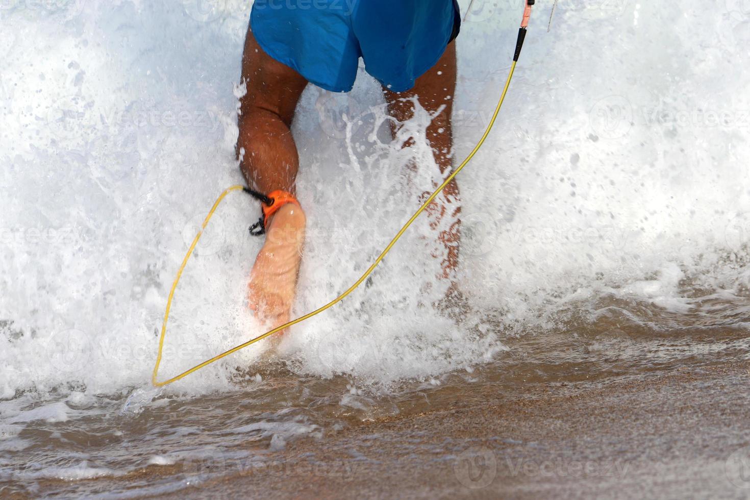 A man walks barefoot on the sand by the sea photo