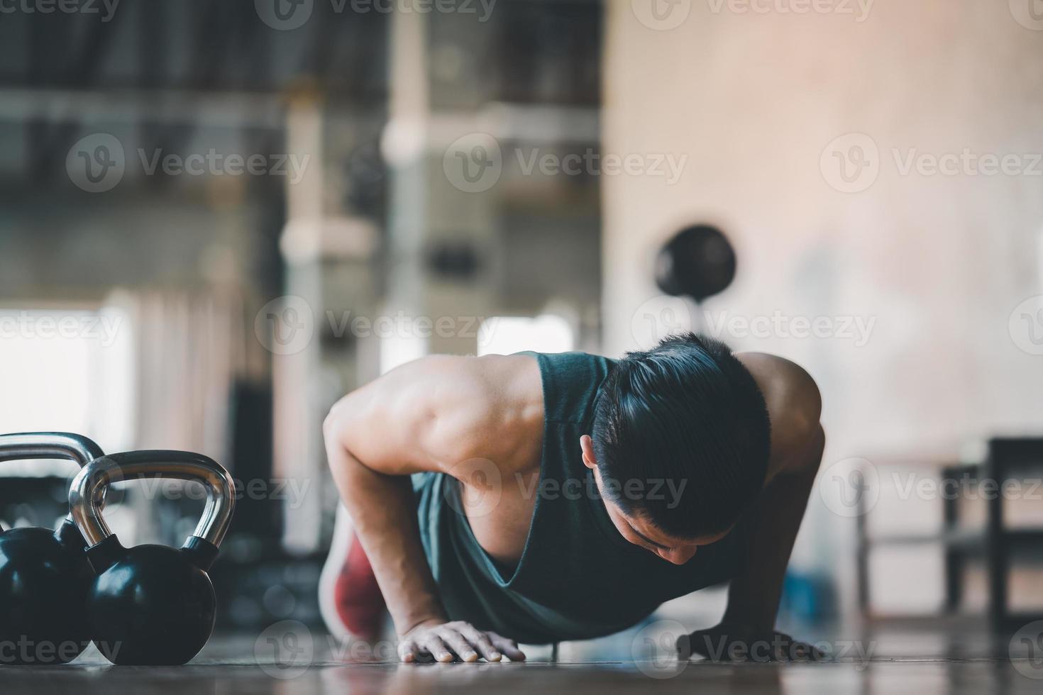 deportista asiático en forma haciendo ejercicio push up en el piso de madera en el gimnasio fitness. ejercicio de hombre deportivo en el centro deportivo. concepto de gimnasio deportivo. foto