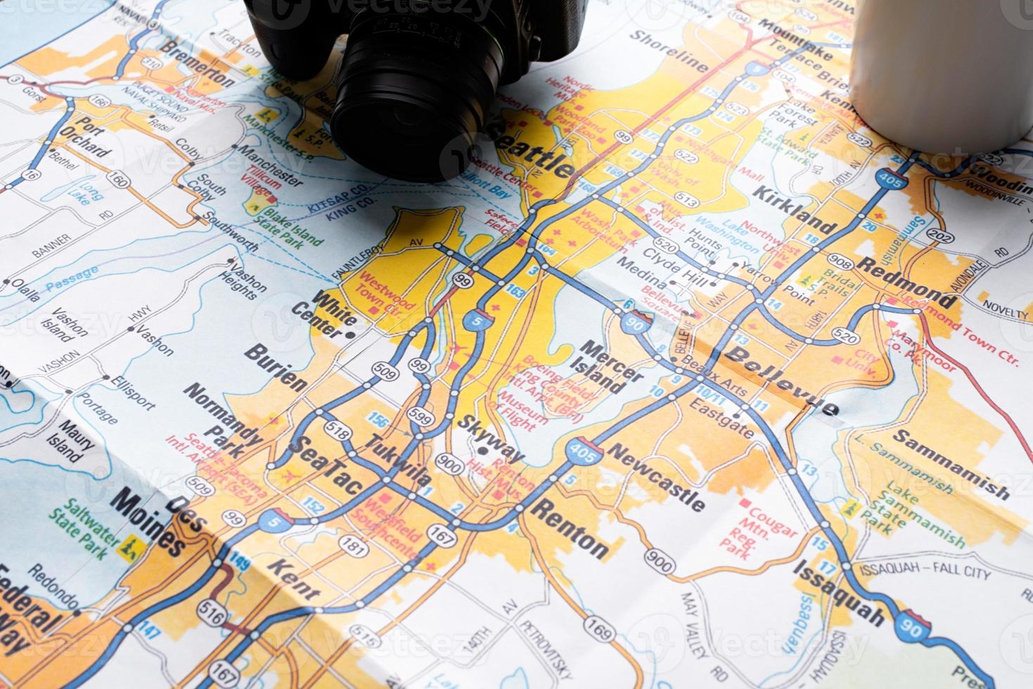 Flat lay traveler accessories on map, camera and cup of coffee photo