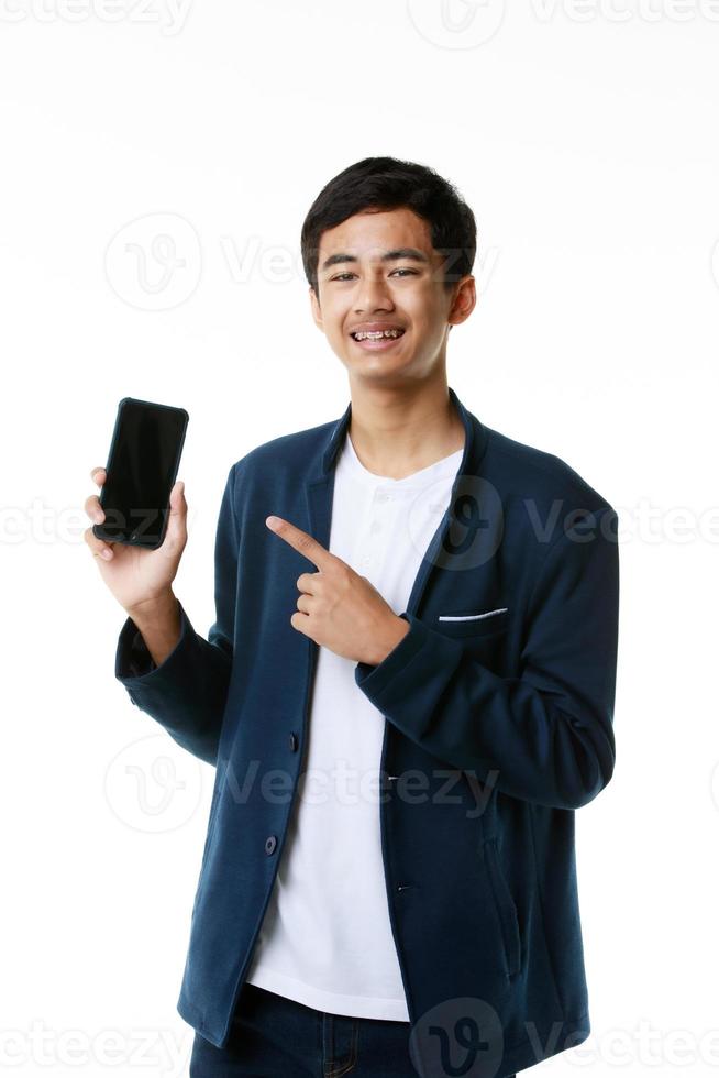 estudiante asiático de secundaria de 15 años sosteniendo y señalando con el dedo una pantalla en blanco de un smartphone. foto