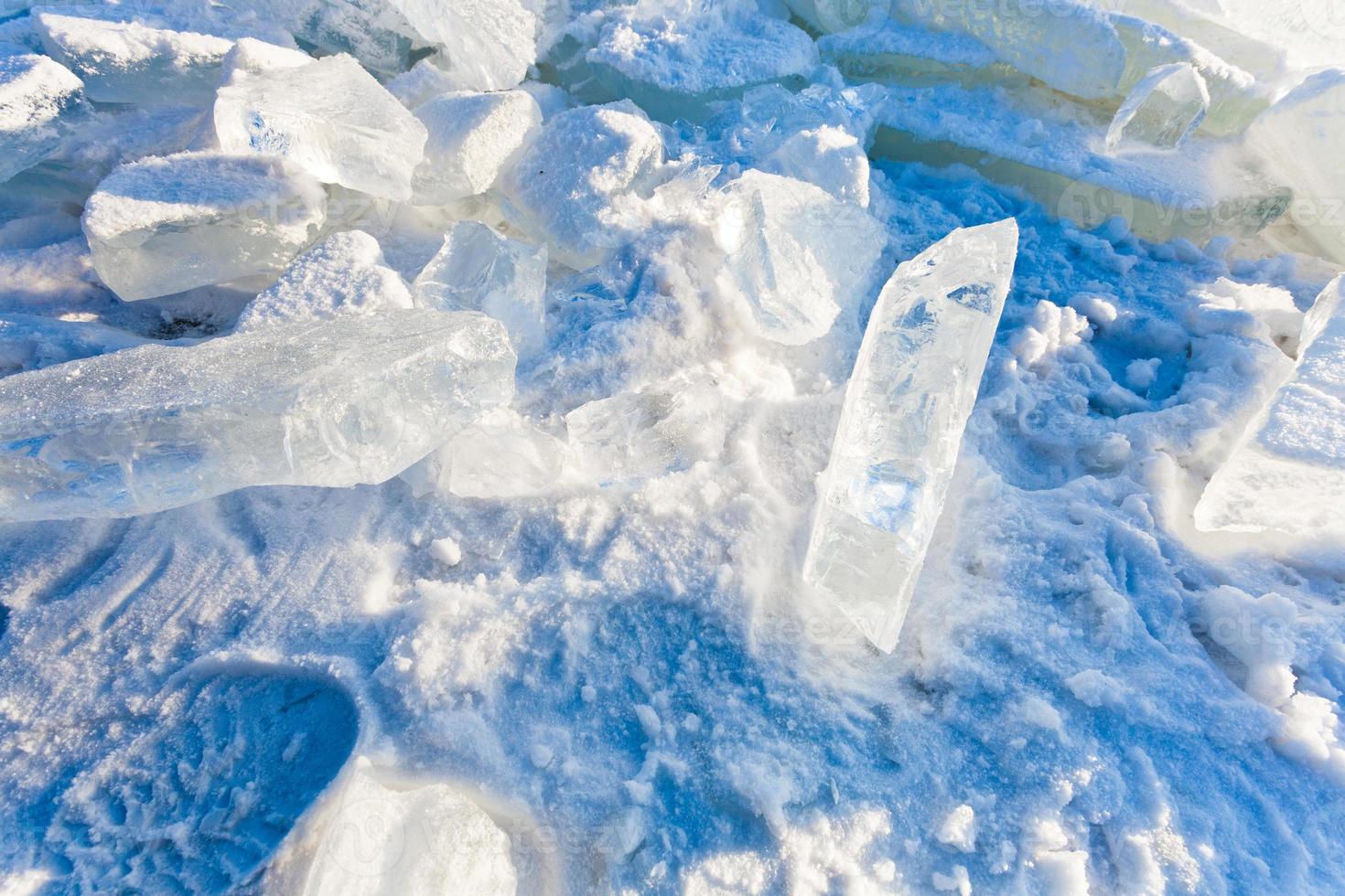 block of clear river ice in cold winter day under sunbeams photo