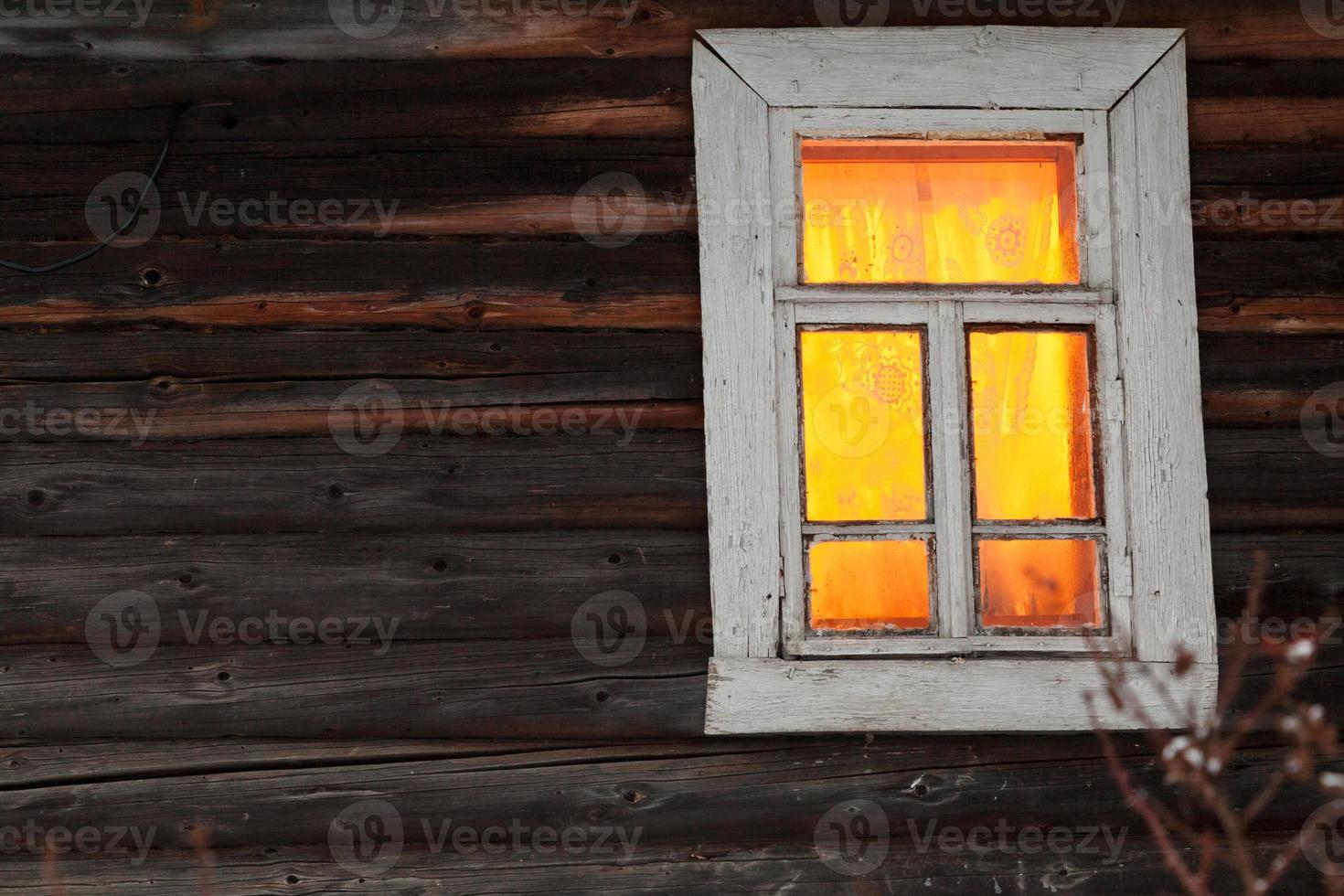 lighting window of rural log house photo