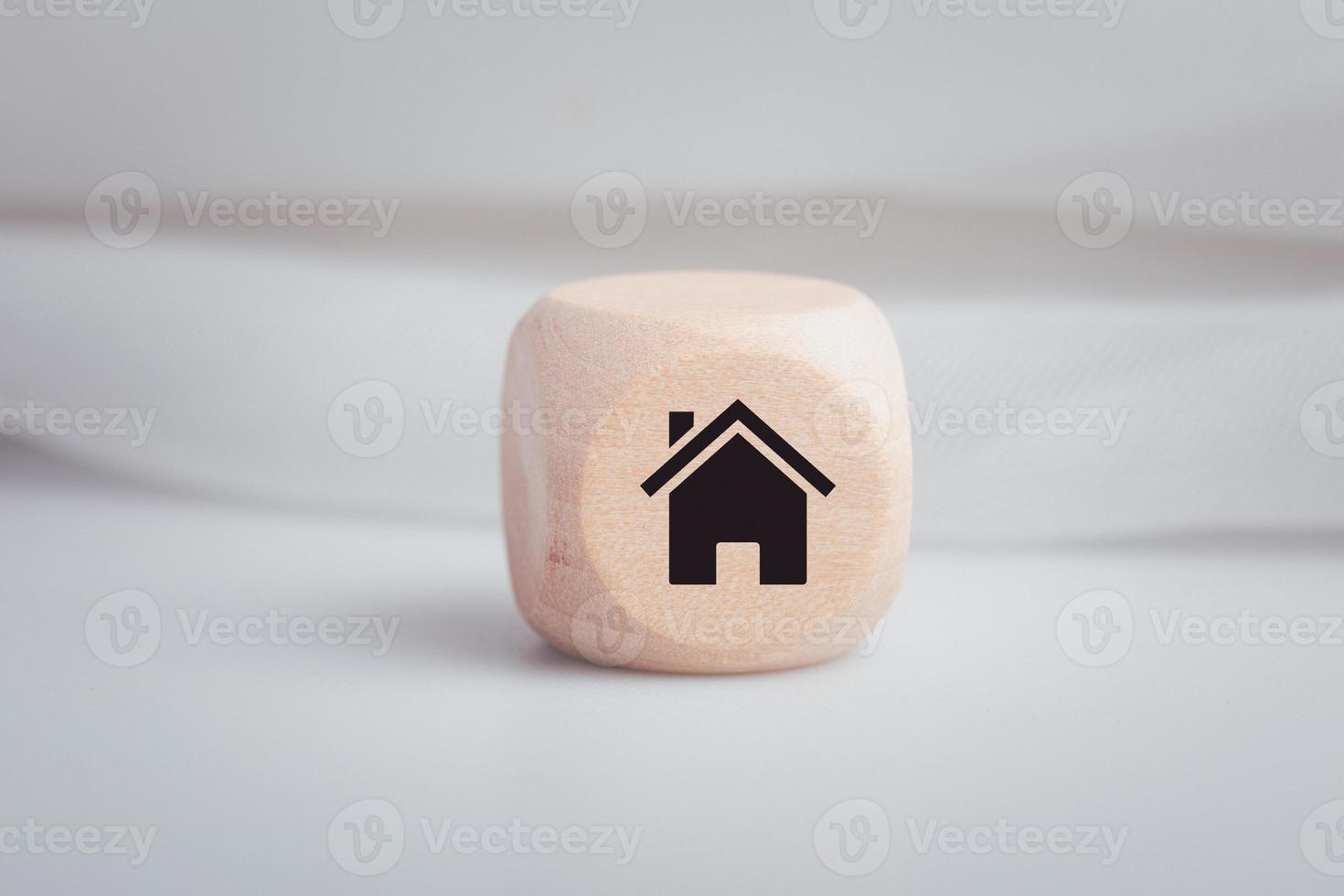 Wooden dice with house symbols on them in a conceptual image. photo