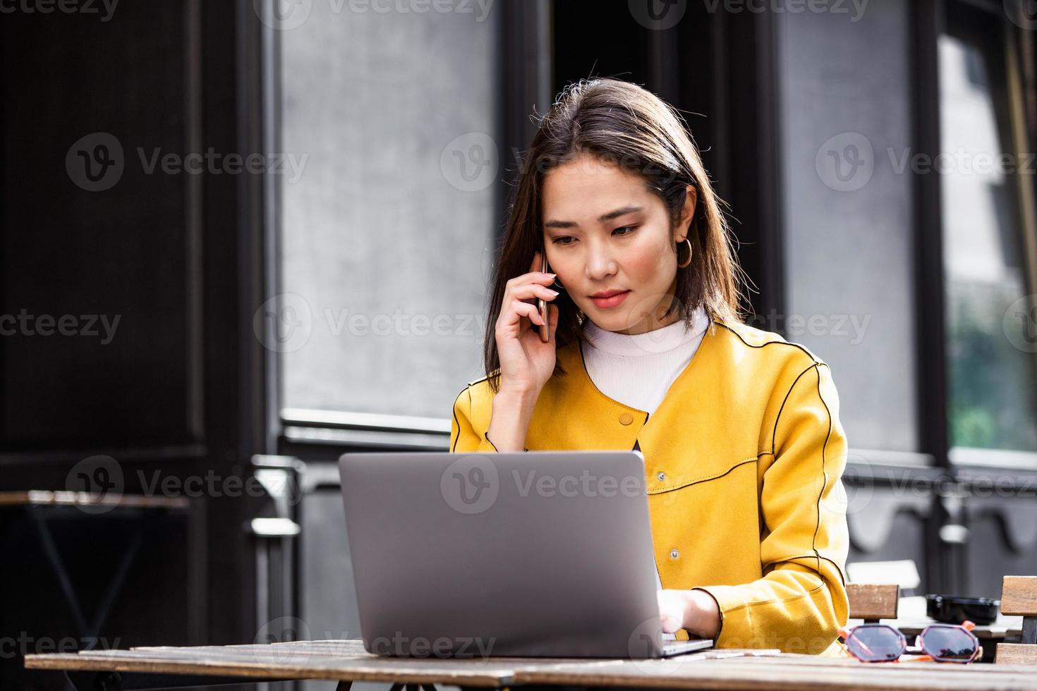 Young Asian businesswoman is working in a cafeteria in her break. Woman taking a break. Enjoying work from coffee shop. Doing Business From coffee shop photo