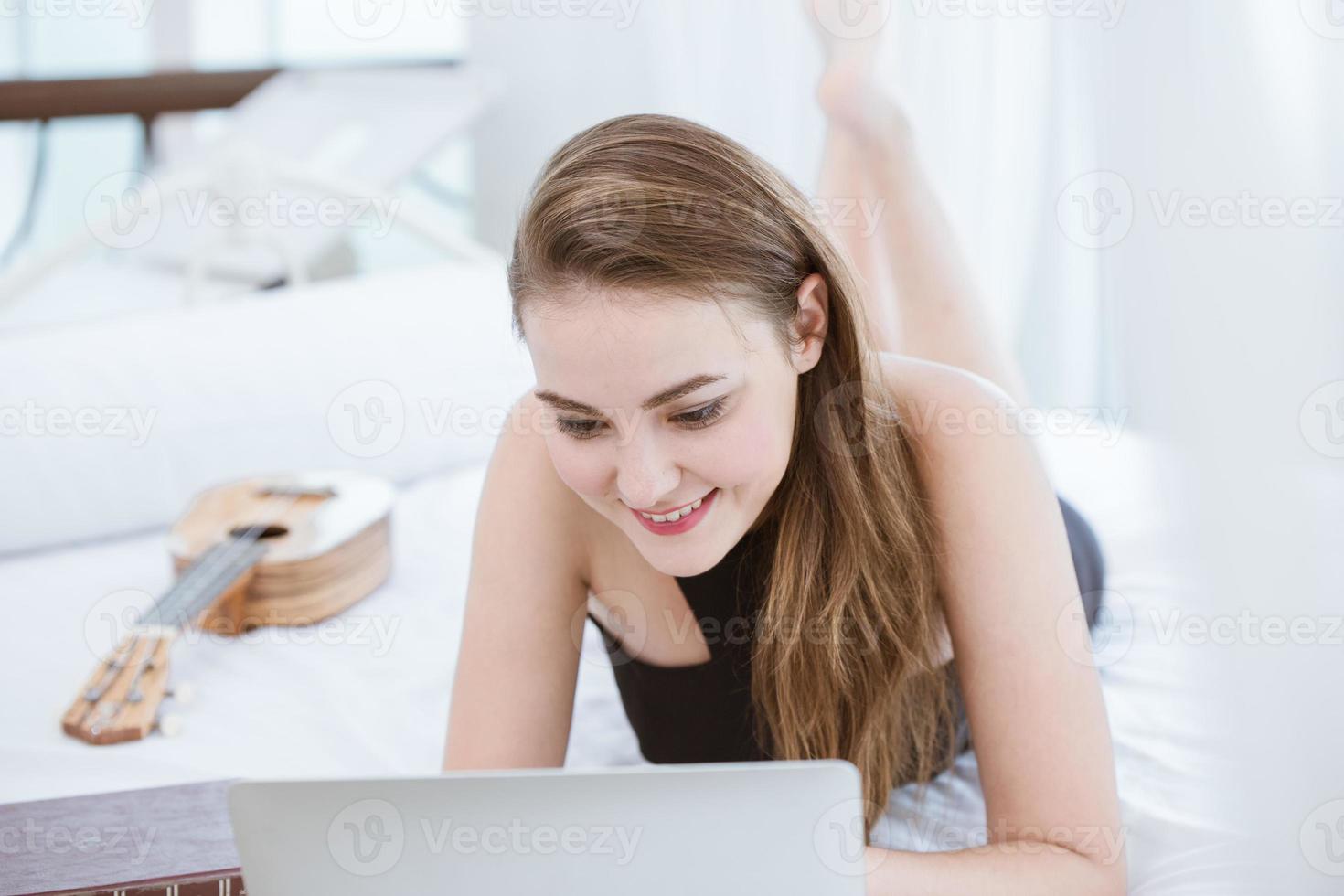 women working at home using laptop computer for work on the bed happy enjot smile photo