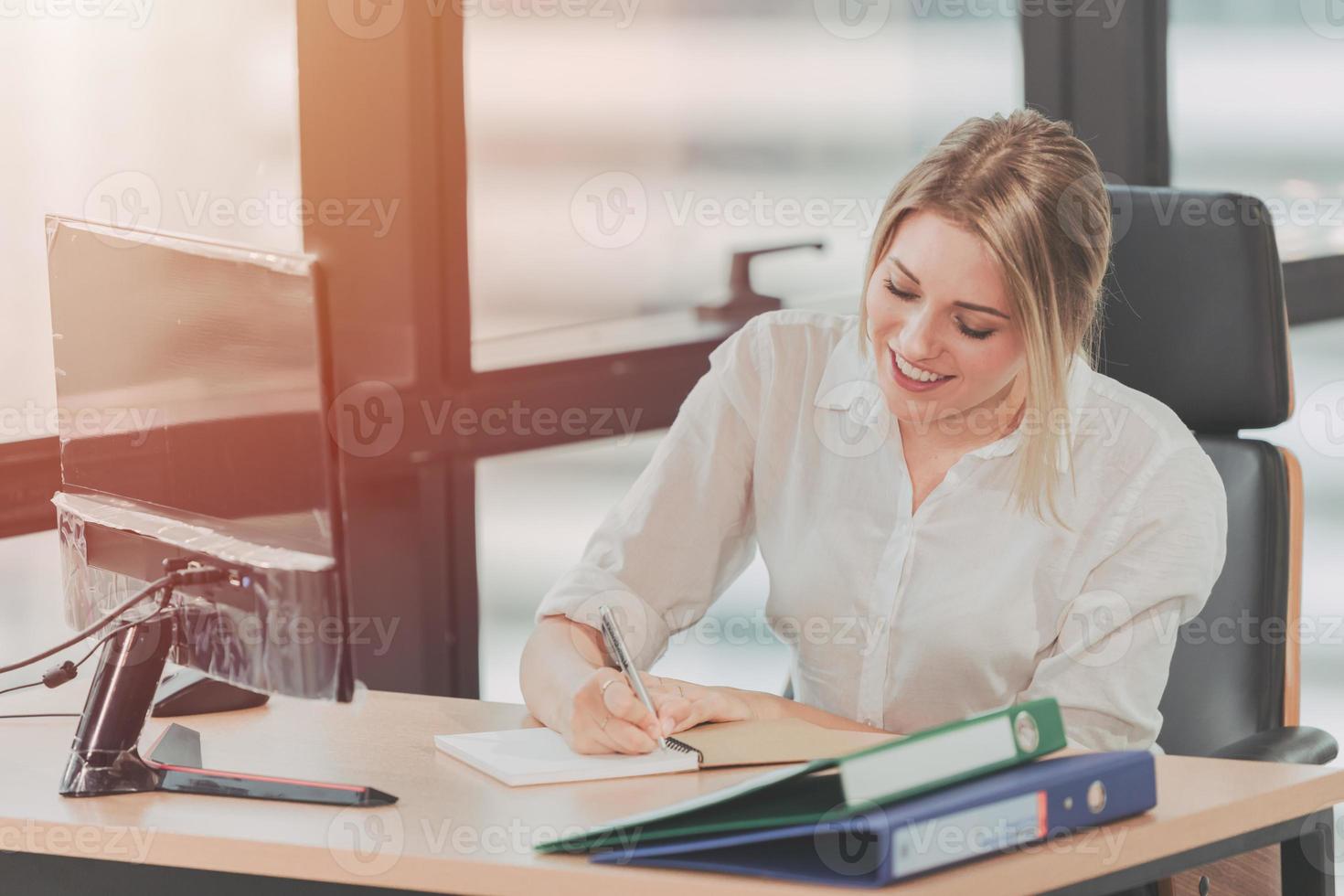 sonrisa feliz joven empresaria ocupada trabajando ocupada en la oficina, recepcionista y asistente personal tomando nota del tono de color vintage foto