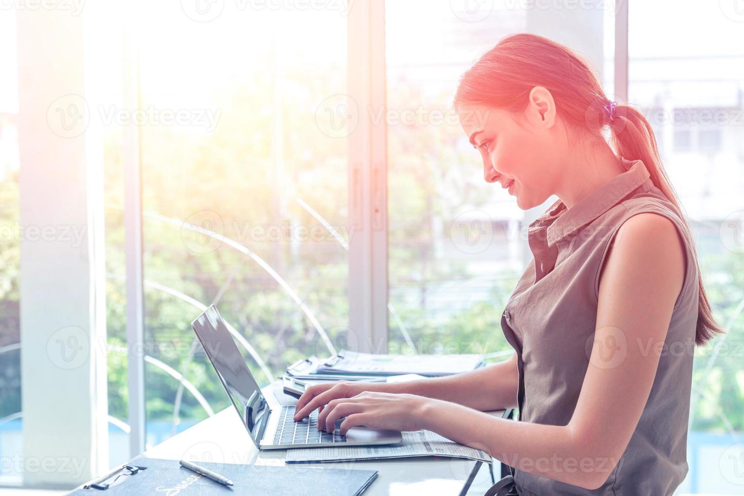 girl work typing on laptop computer business in office windows portait side view photo