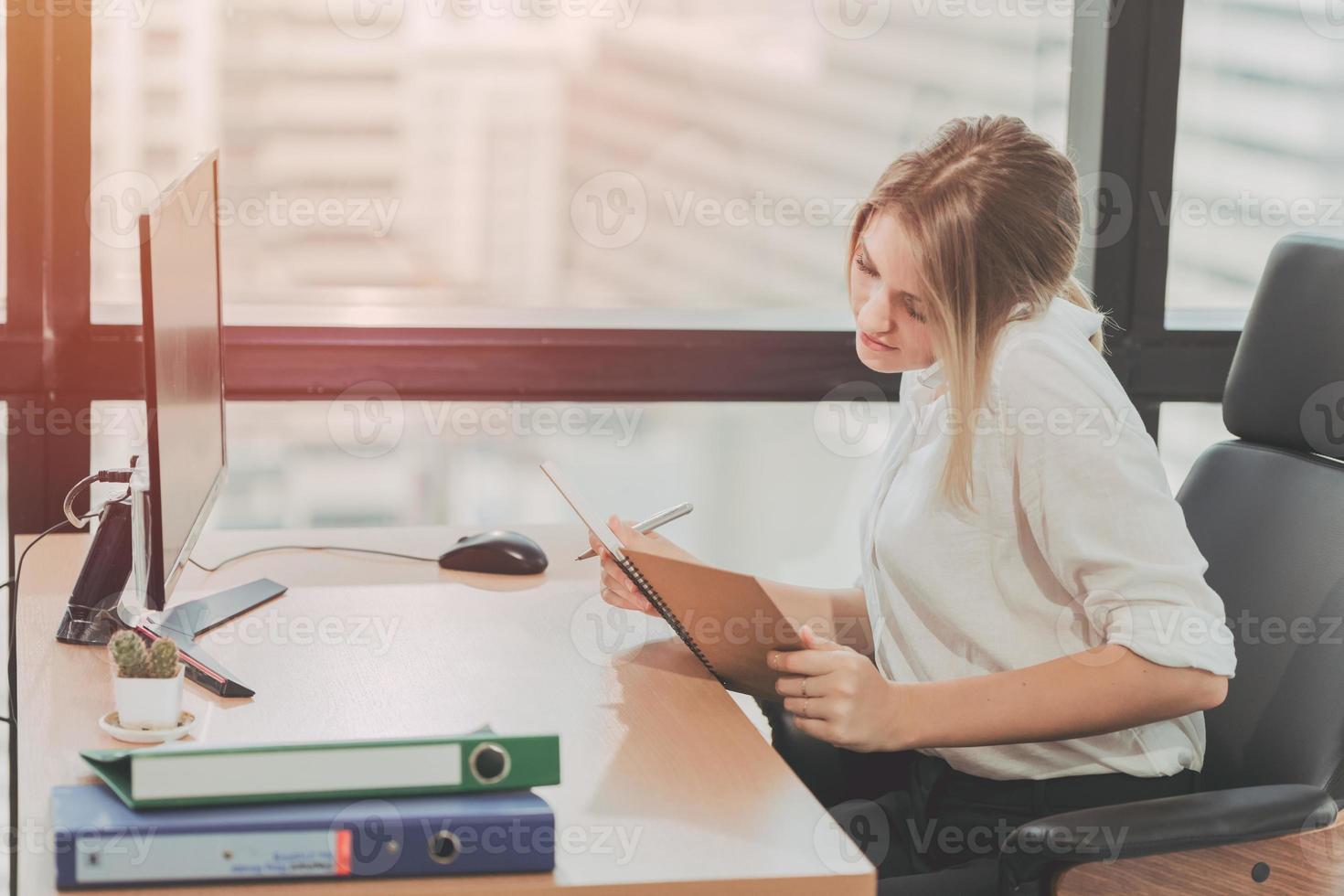 joven empresaria ocupada trabajando en la oficina, recepcionista y asistente personal tomando nota del tono de color vintage foto