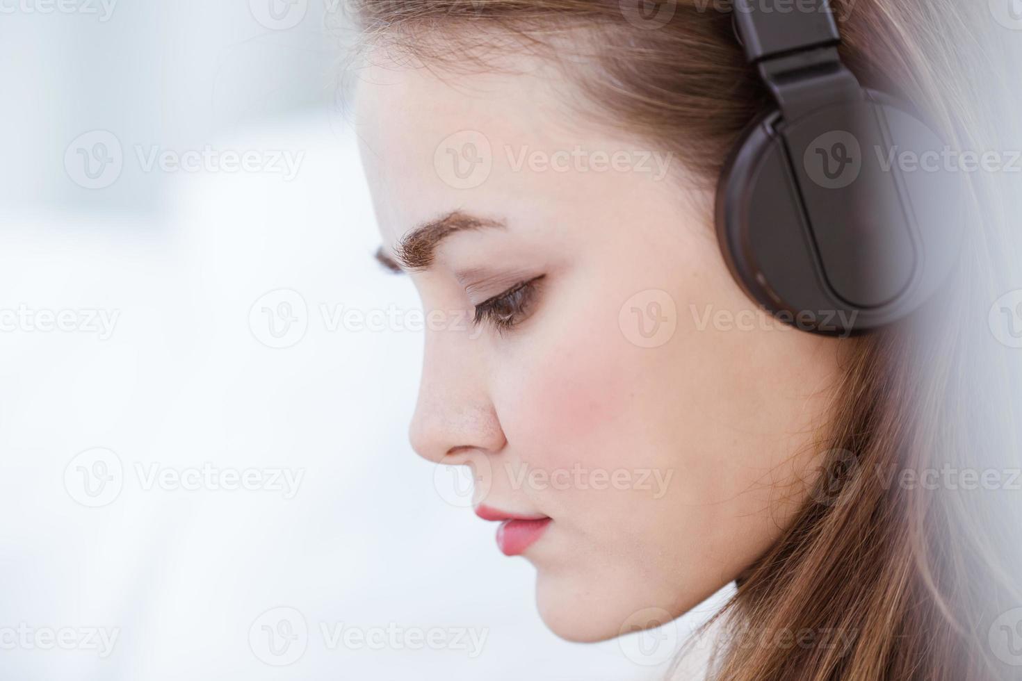 primer plano hermoso retrato de mujer asistir a escuchar música usando auriculares inalámbricos estado de ánimo serio foto