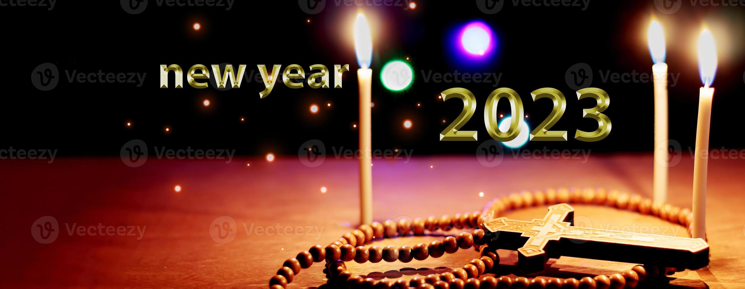 2023 written on black background and yellow candles happy new year background concept photo