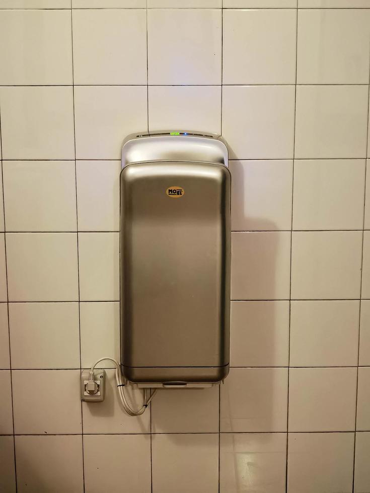 electric hand dryer for bathroom, in a public toilet for paper saving photo