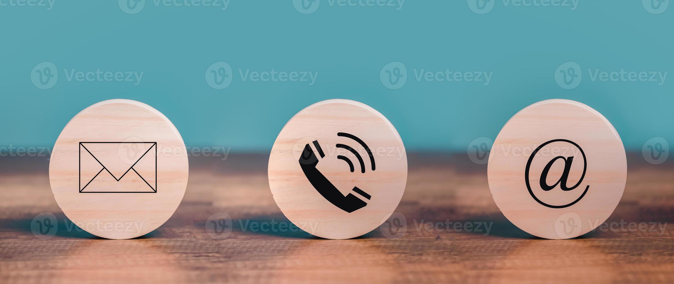 Customer Contact Us Service with Mail, Email, Telephone icons on the circle wooden  put on the desk. photo