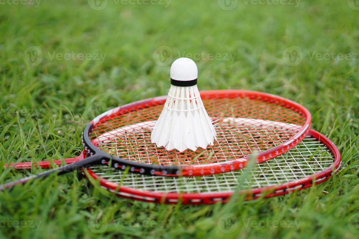 Badminton shuttlecock and racket on grass floor. Concept , Sport with equipment, workout. Recreational sport that can be played for fun or exercise and competition in team or individual. photo