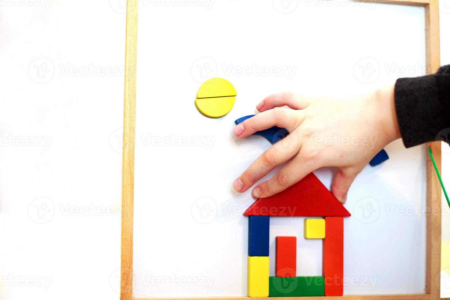 child plays wooden magnetic educational game. girl plays with a toy photo