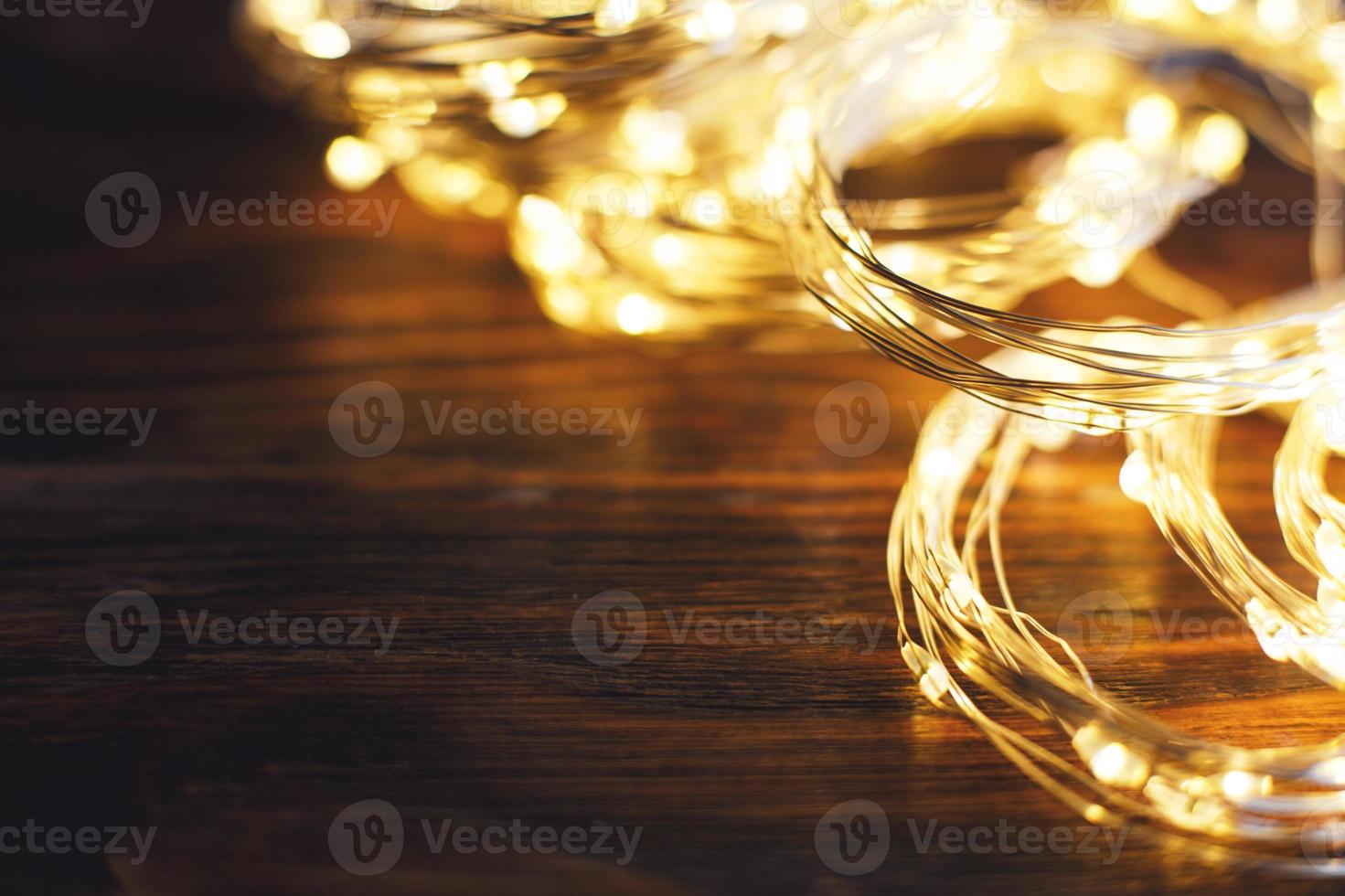 christmas beautifull shiny gold garland on a wooden brown background. sparkle festive background photo