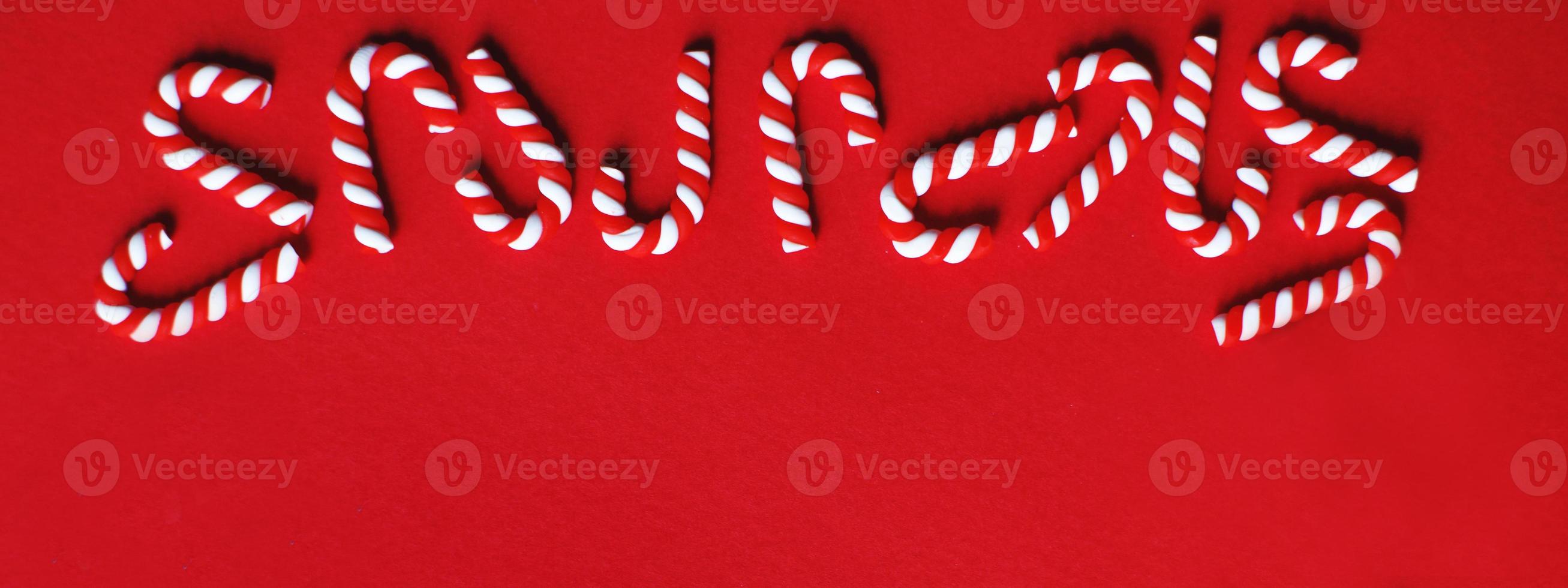 Christmas composition with frame of candy canes on a red background. Copy space for text. banner photo