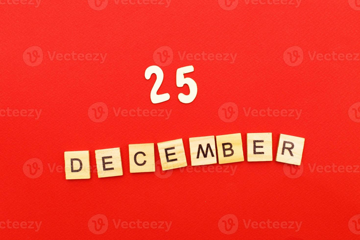 inscription December 25 made by wooden cubes on a red background. photo