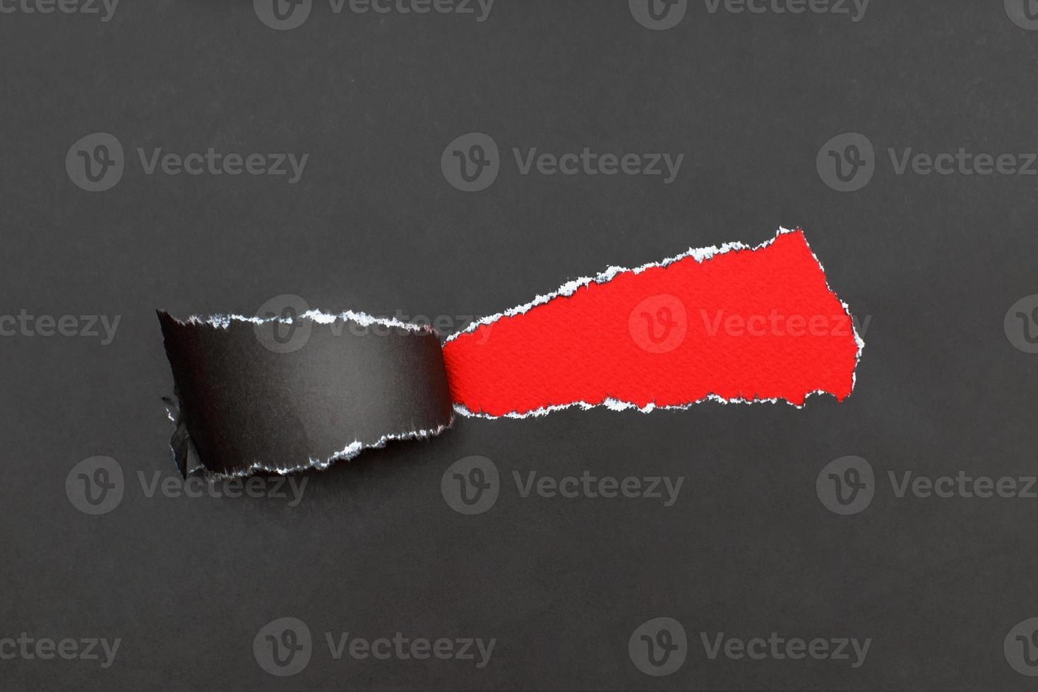 curl of torn black paper on red background. advertising and sale concept. copy space photo