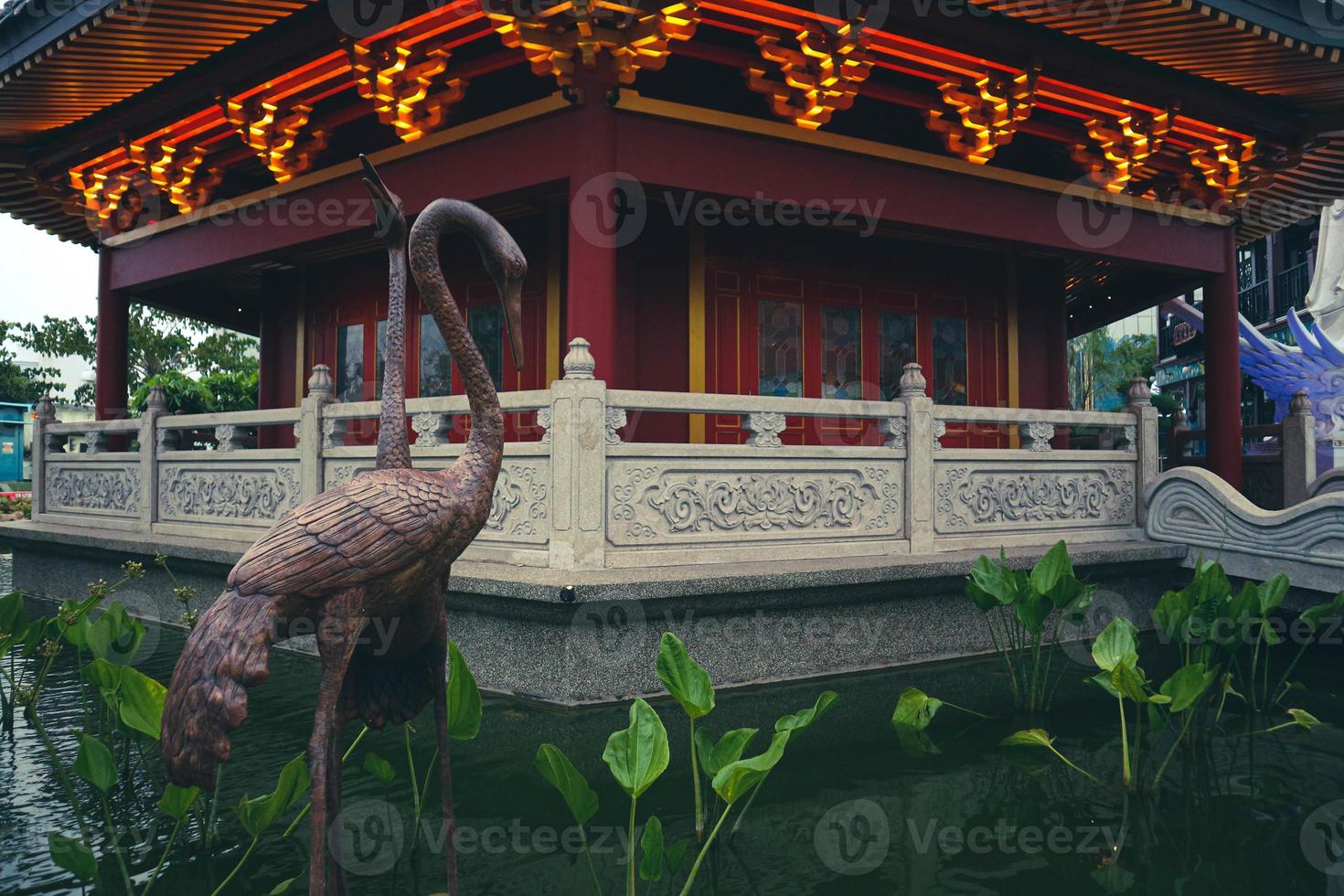 A Pagoda in the center of a Chinatown with a brown stork statue. photo