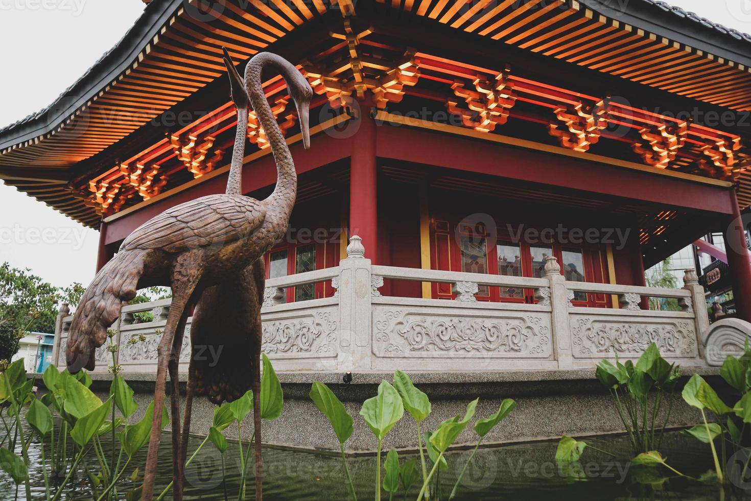 A Pagoda in the center of a Chinatown with a brown stork statue. photo