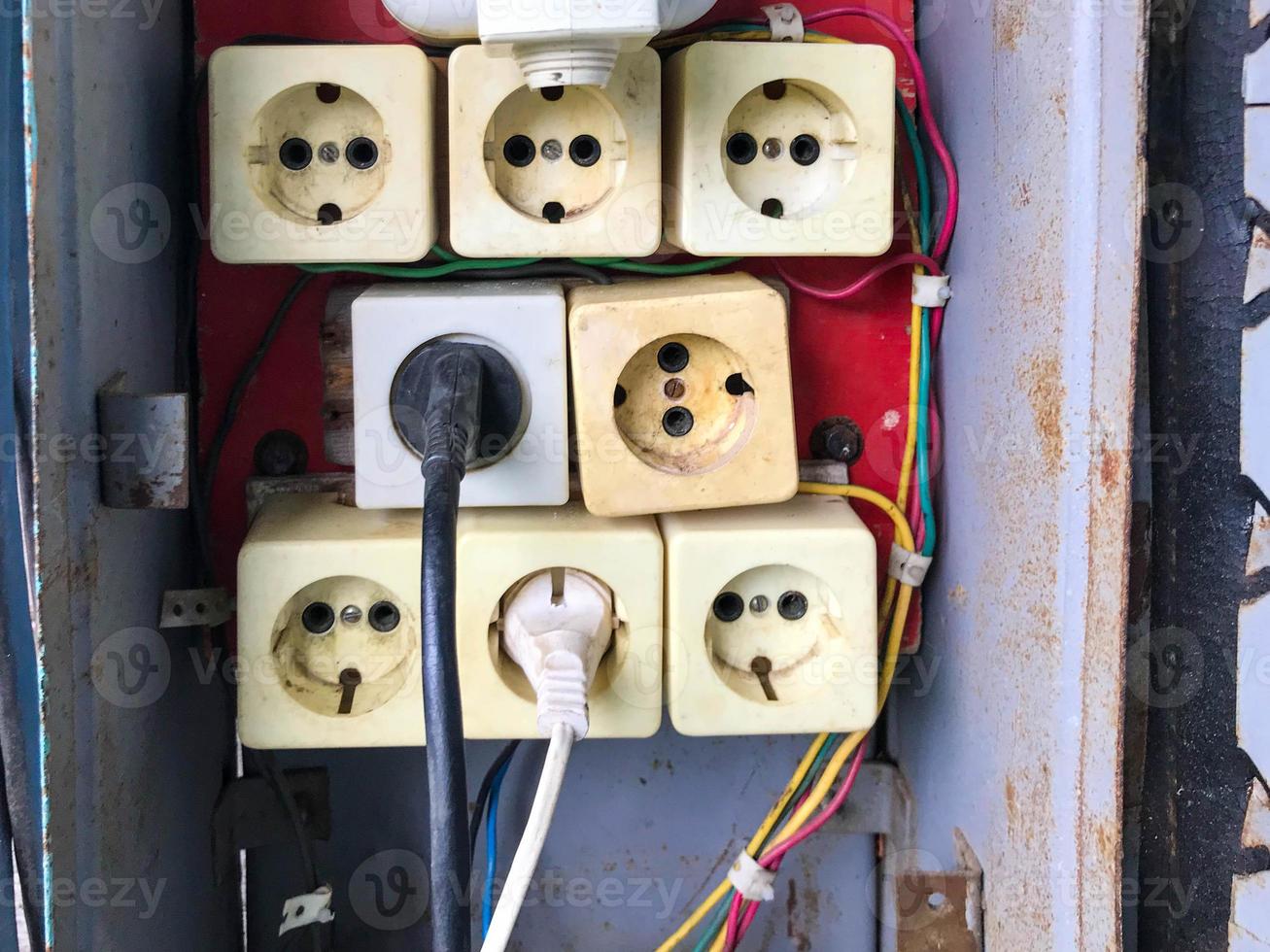 switch box. homemade shield with sockets for power lines. providing the house with light and heat. do it yourself wires. building a house in the village, many white sockets in a gray panel with wires photo
