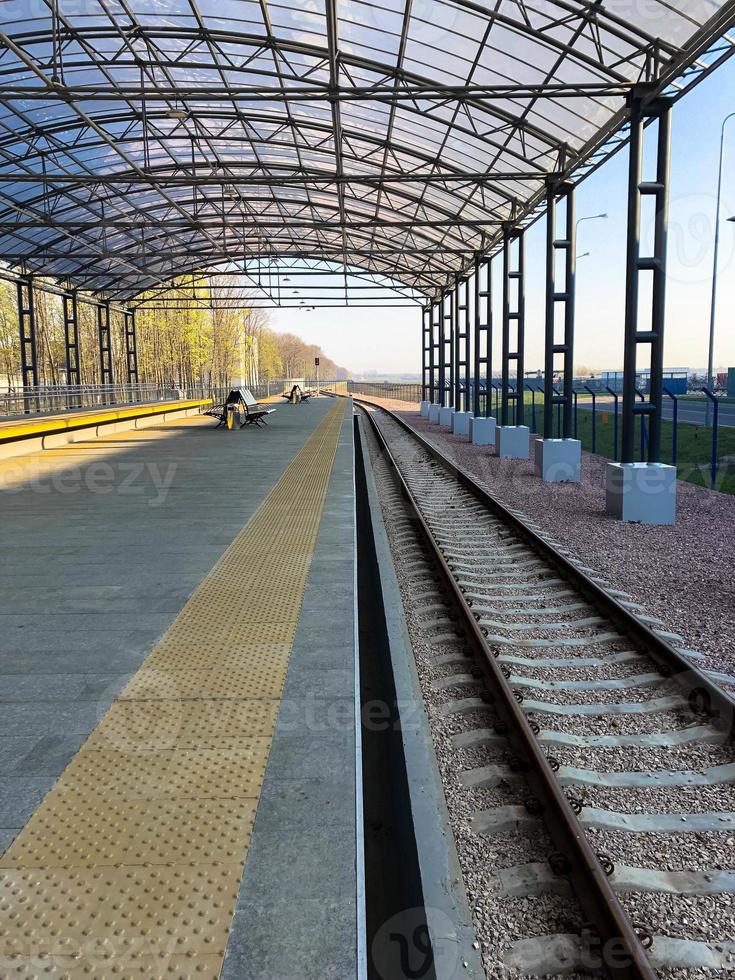 Modern railway station, train station with a transparent canopy for passengers and rails photo