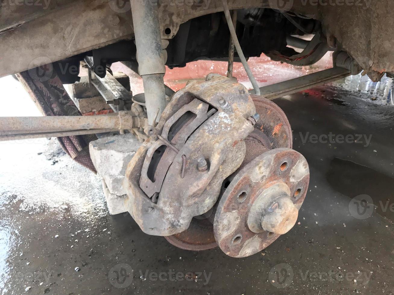 Old rusty worn brake discs, pads of a truck, car. Car suspension repair. Replacing wheel photo