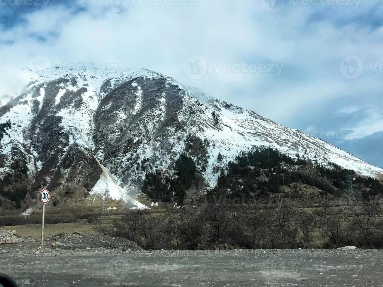 hermosos paisajes de invierno frío de montaña con picos de alta montaña niebla y rocas cubiertas de nieve para el snowboard y el esquí contra un cielo azul foto