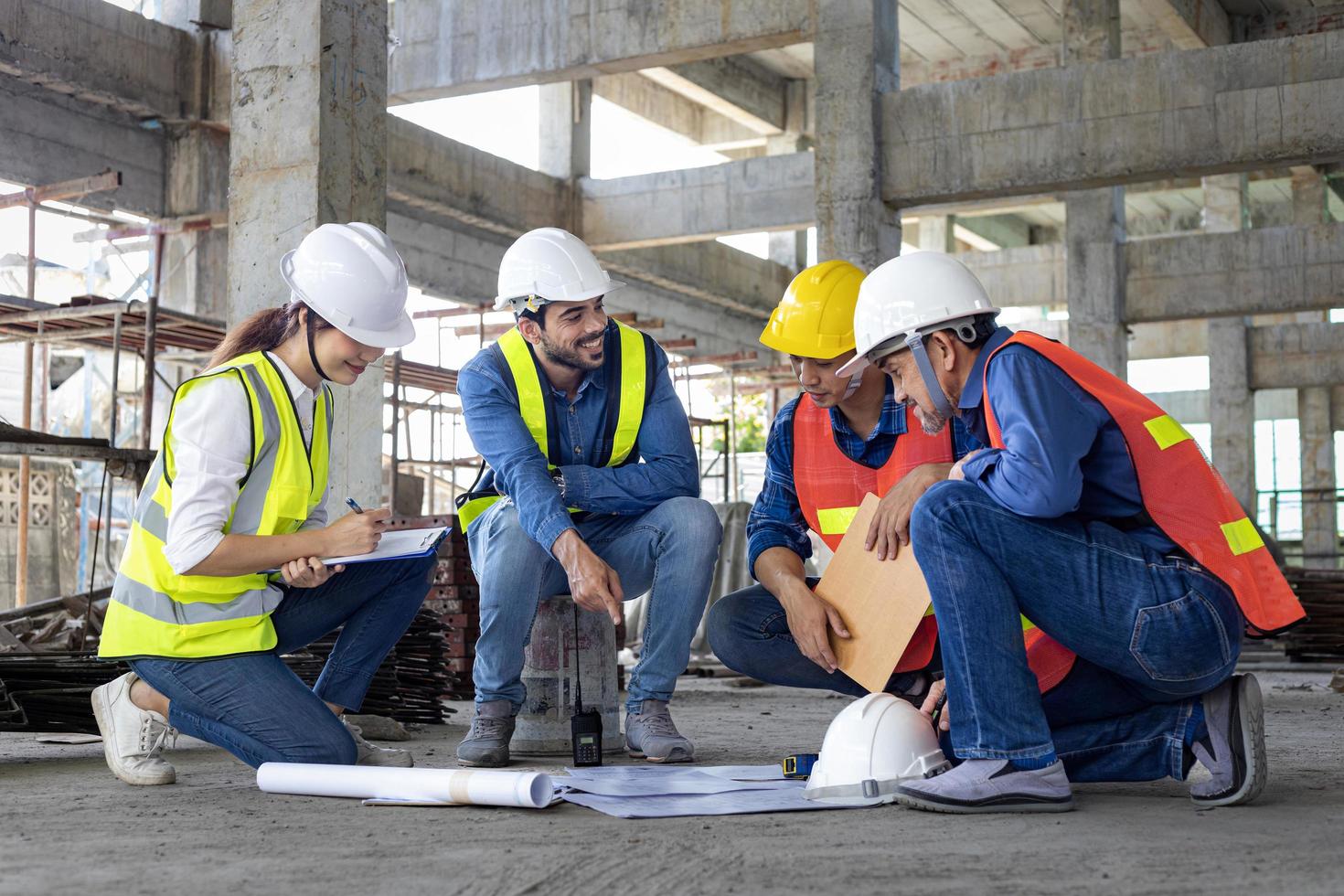 equipo de ingenieros, arquitectos, contratistas y capataces reunidos y consultores en el sitio de construcción con plano de planta para la industria de proyectos de desarrollo inmobiliario y el concepto de línea de tiempo de vivienda foto