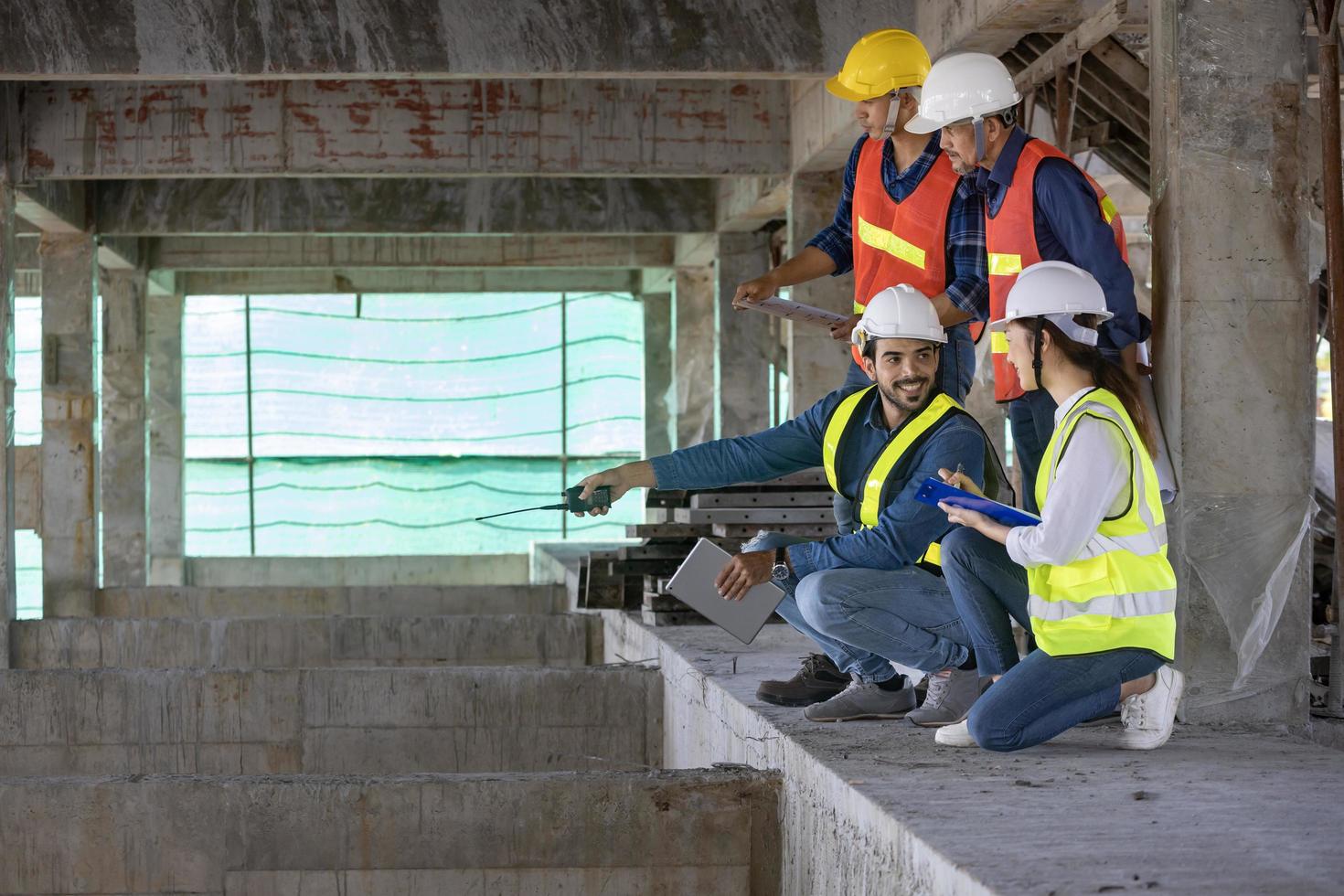 equipo de ingenieros, arquitectos, contratistas y capataces reunidos y asesorados en el sitio de construcción para inspección en la industria de proyectos de desarrollo inmobiliario y control de calidad de especificaciones foto