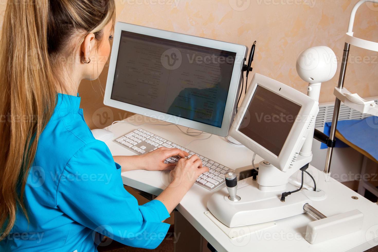 woman doctor typing at the working computer photo