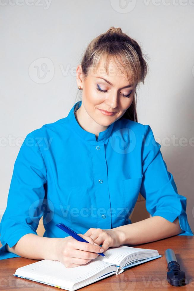 pretty girl doctor takes notes on a workplace photo