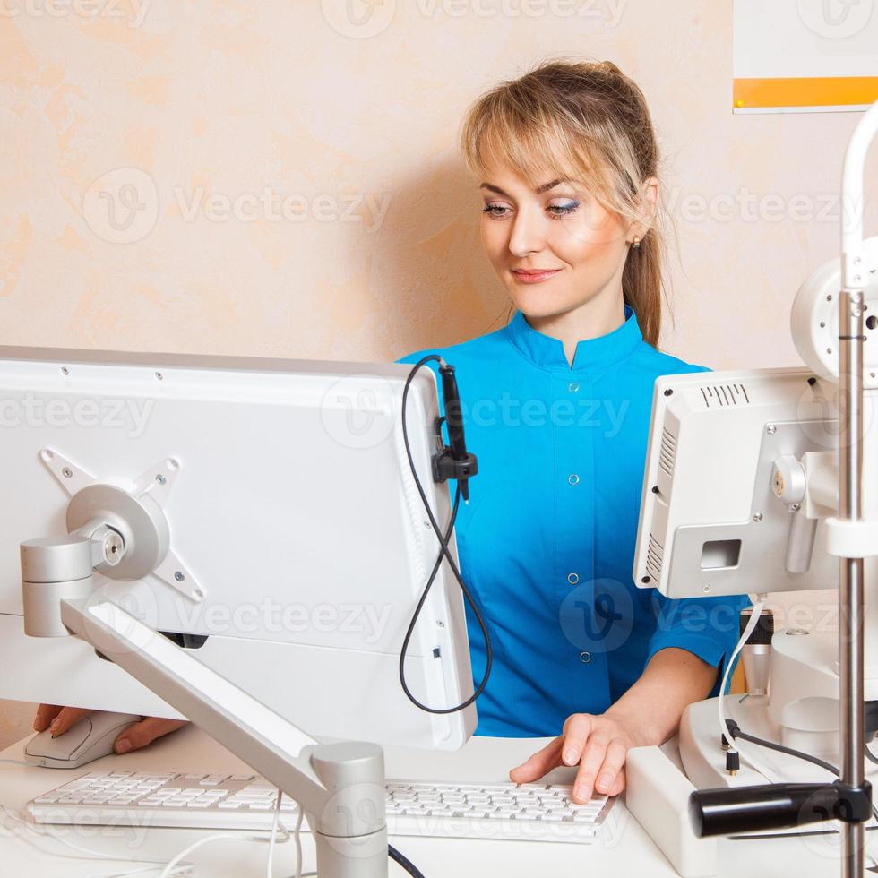 square portrait of beautiful young adult doctor works at computer photo