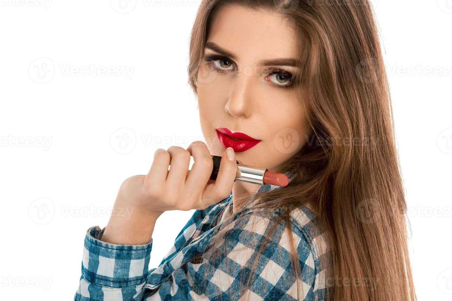 Close up photo of young caucasian girl with lipstick in hand