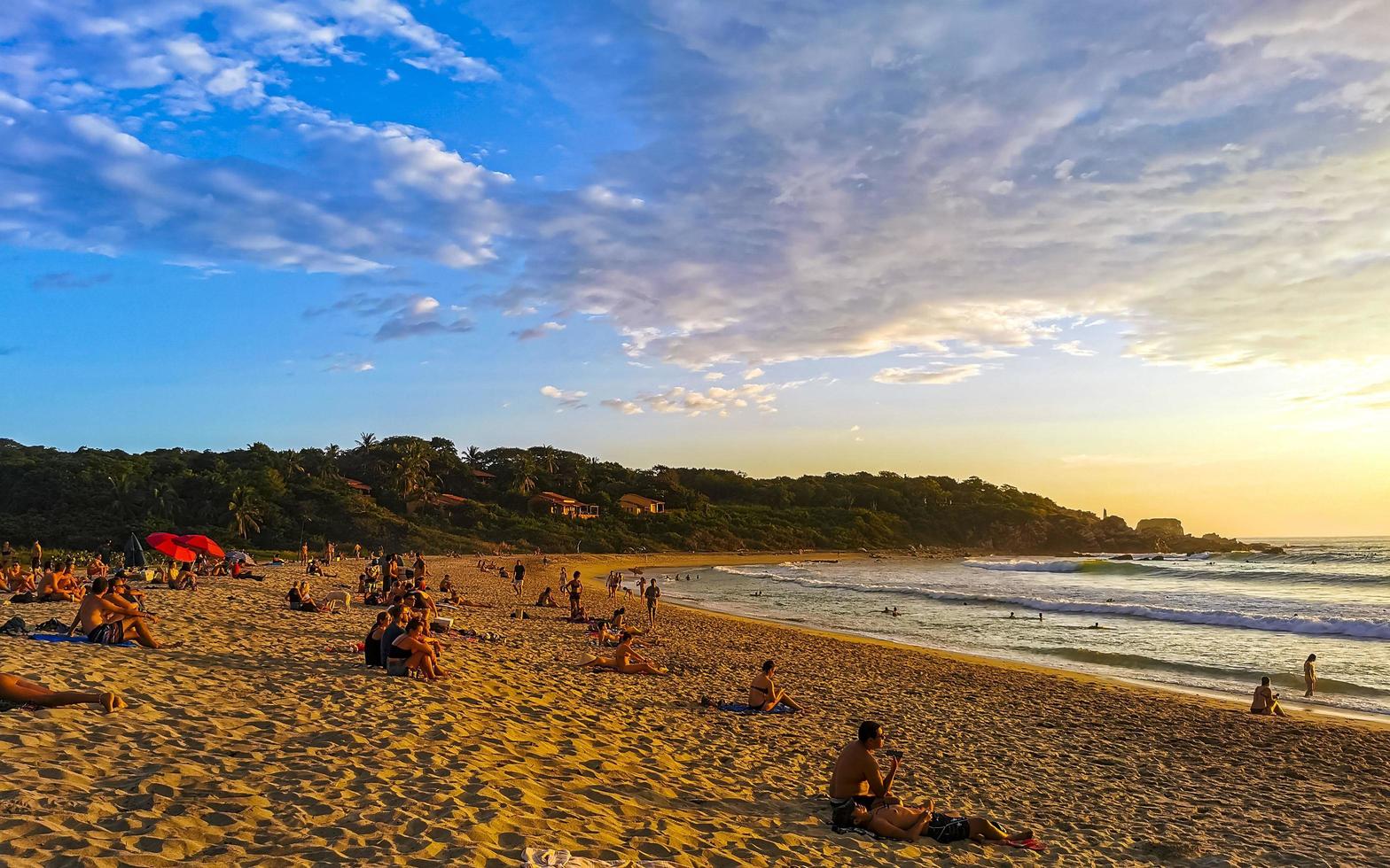 Puerto Escondido Mexico Oaxaca Mexican 2022 Colorful golden sunset people wave and beach Puerto Escondido Mexico. photo