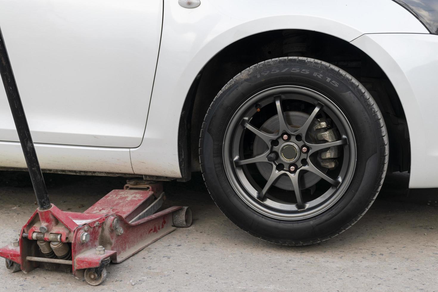 White cars change wheels using a lifting jack. photo