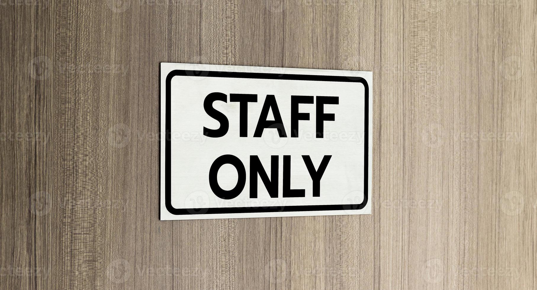 Warning silver stainless steel sign with character black message staff only in front of the wooden door photo