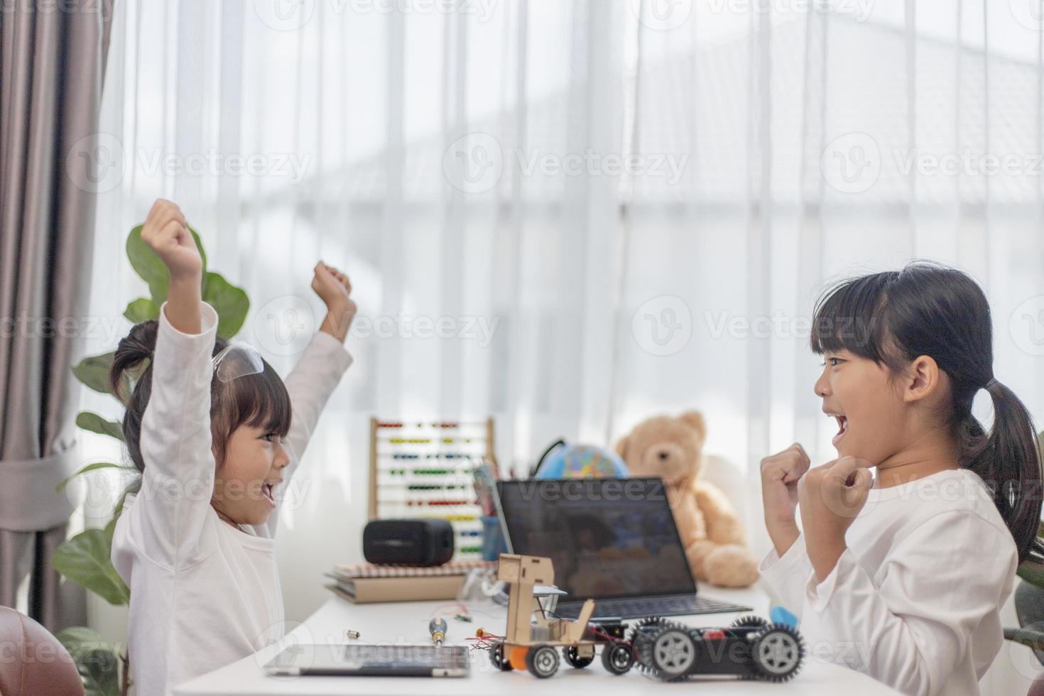 dos estudiantes asiáticos aprenden a codificar autos robot y cables de tableros electrónicos en tallo, vapor, ingeniería matemática, ciencia, tecnología, código de computadora en robótica para conceptos de niños. foto