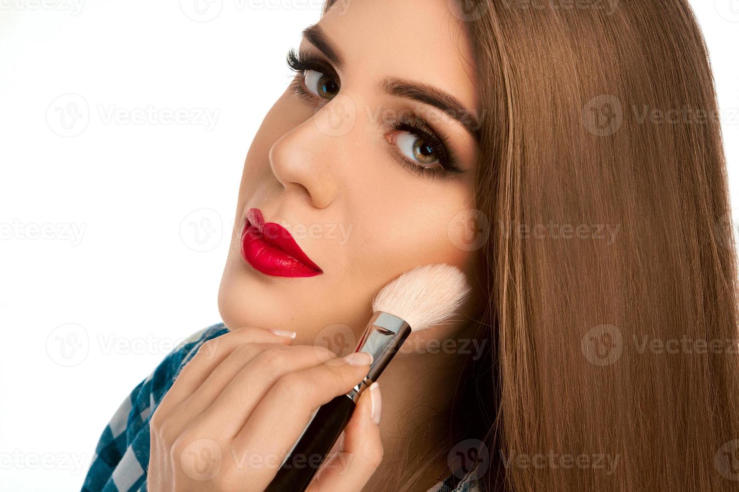 linda joven hace un maquillaje con cepillo foto