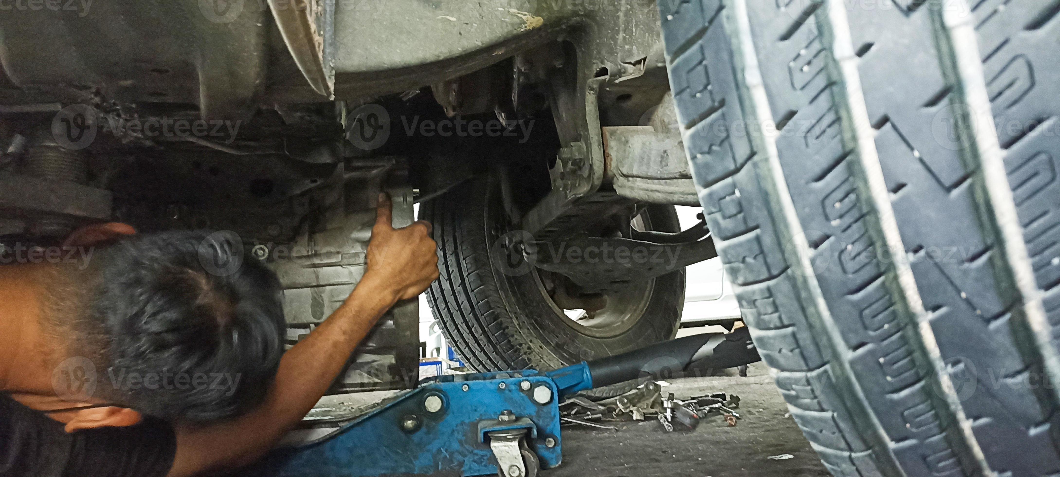 Car undercarriage and mechanic repairing undercarriage of the car