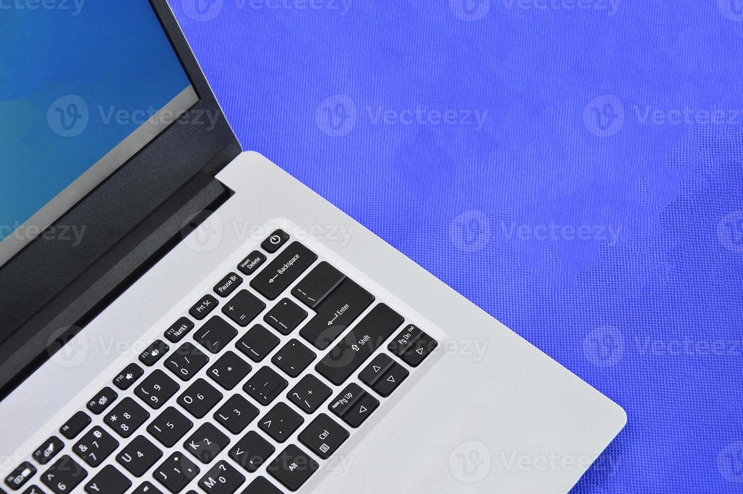 top right view of a white laptop on a blue background photo