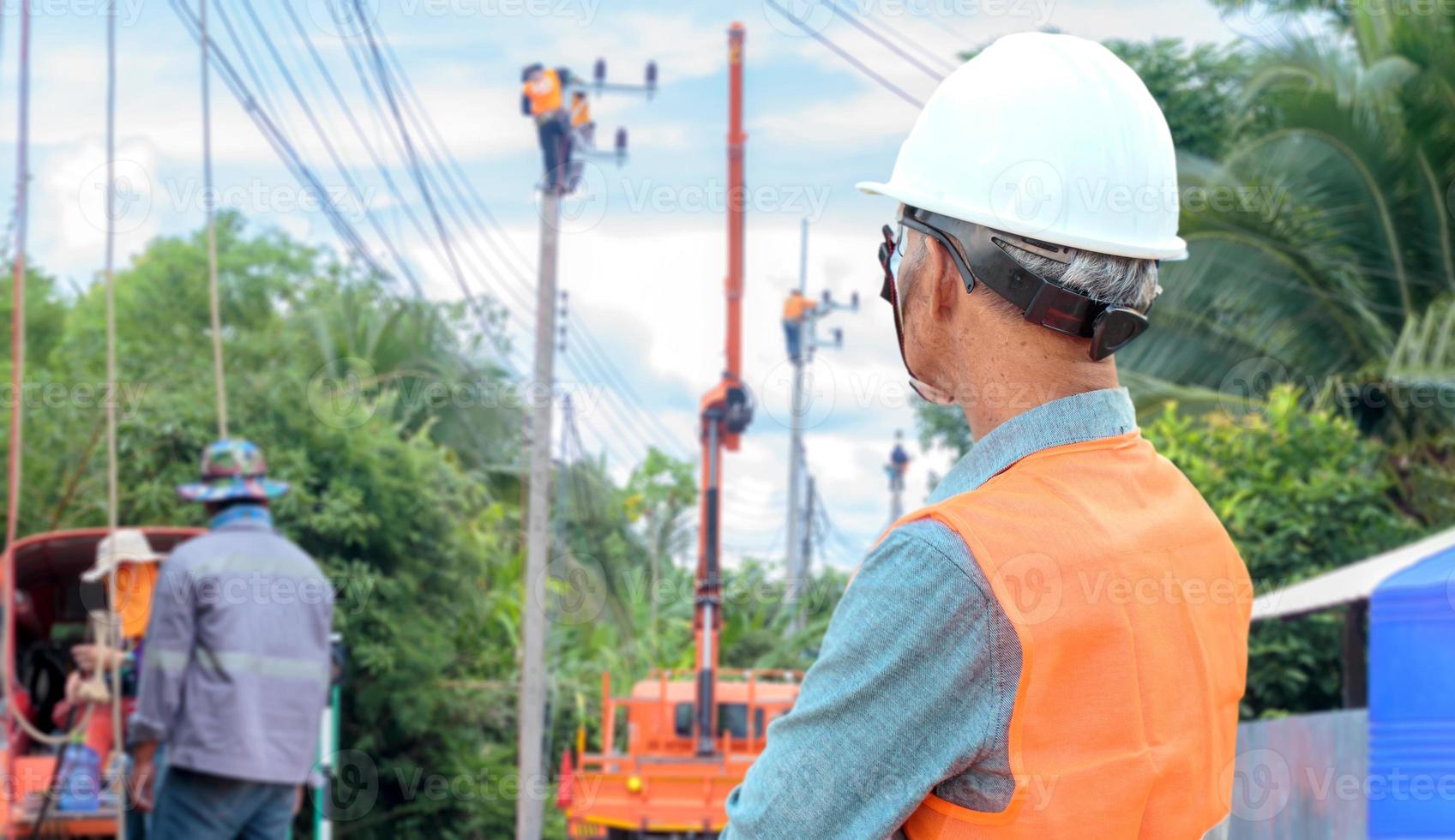 electrical engineer watching the work of workers photo
