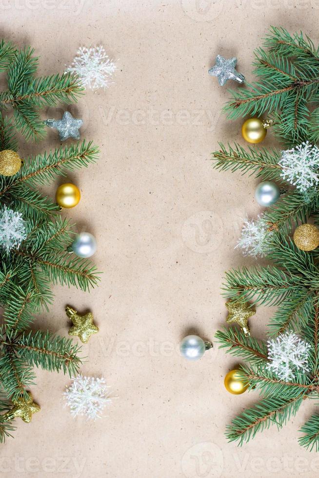 border of fir tree branch with gold decoration on craft paper for christmas card with copy space for text. photo