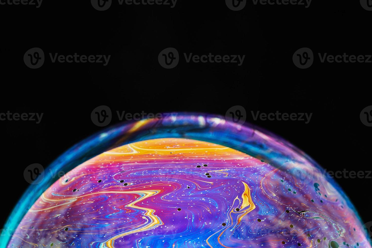Virtual reality space with abstract multicolor psychedelic planet. Closeup Soap bubble like an alien planet on black background. photo
