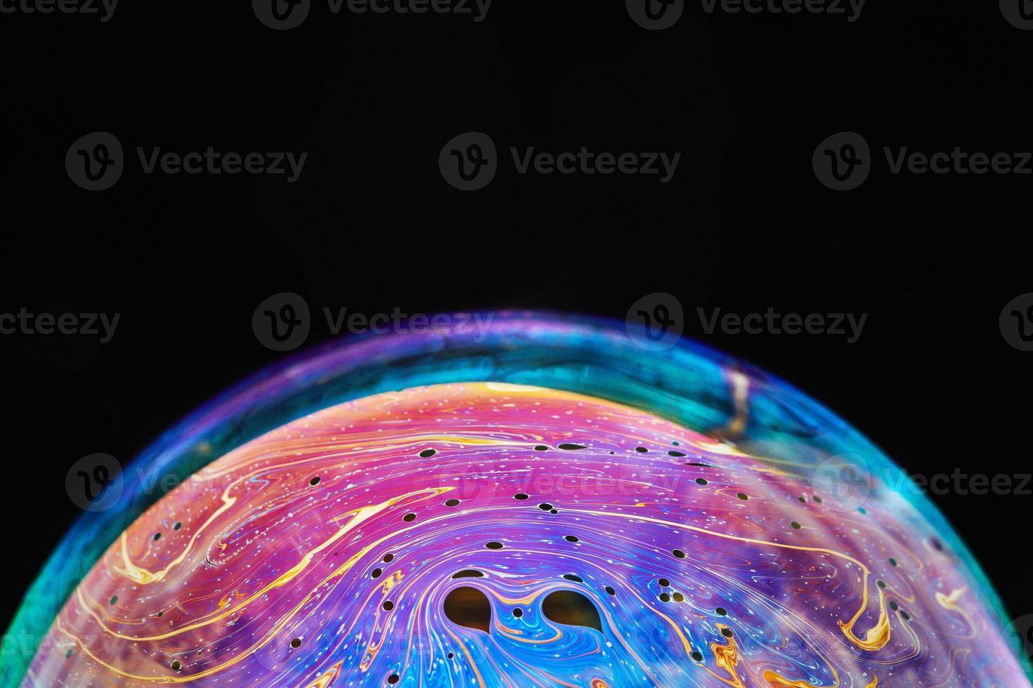 Virtual reality space with abstract multicolor psychedelic planet. Closeup Soap bubble like an alien planet on black background. photo